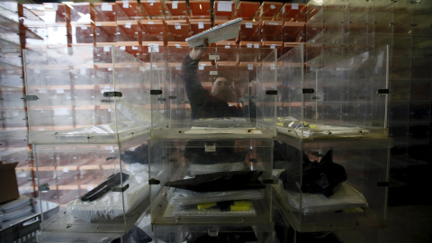 Un operario prepara las urnas para la jornada electoral del 20-D. REUTERS Un operario prepara las urnas para la jornada electoral del 20-D. REUTERS