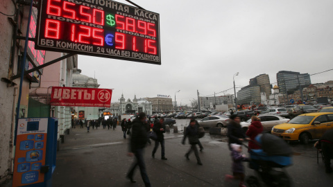 Un grupo de moscovitas pasa ante una oficina de cambio de moneda en Moscú. Un grupo de moscovitas pasa ante una oficina de cambio de moneda en Moscú.