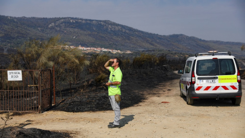 Un trabajador mira un incendio durante esta semana en España. Un trabajador mira un incendio durante esta semana en España.