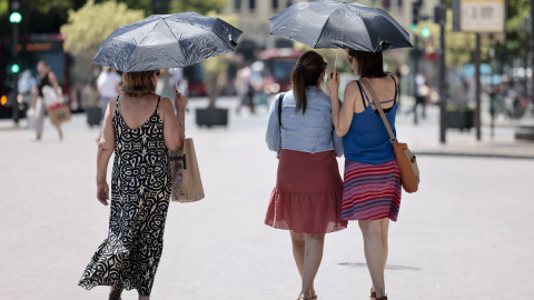 Tres mujeres se protegen del calor con unos paraguas en Valéncia a 4 de julio de 2023. Tres mujeres se protegen del calor con unos paraguas en Valéncia a 4 de julio de 2023.