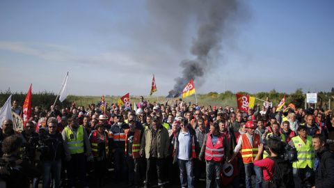 Miembros de un sindicato francés en huelga se reúnen cerca de una barricada de fuego que bloquea la entrada del depósito de la empresa SFDM cerca de la refinería de petróleo, contra la propuesta de ley de reforma laboral en Donges , Francia