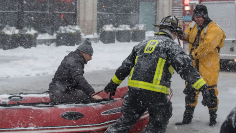 Bomberos de Boston rescatan a un hombre en medio de una tormenta de nieve. EFE/JOHN CETRINO