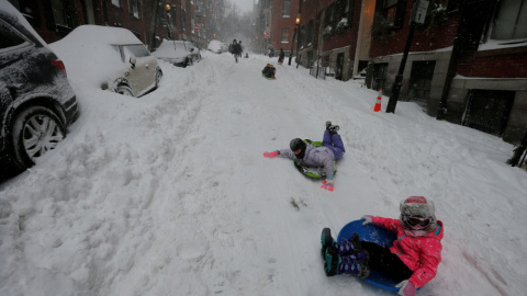 Un grupo de niños se desliza por una de las calles nevadas de Boston, en plena tormenta. REUTERS/Brian Snyder