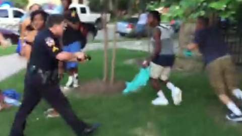 Momento en el que el agente suspendido saca su arma ante un grupo de adolescentes. Momento en el que el agente suspendido saca su arma ante un grupo de adolescentes.