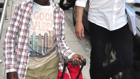 El pequeño Adou, conocido como "niño de la maleta", junto a un funcionario del Area de Menores, momentos antes de encotrarse con su madre. EFE/Reduan El pequeño Adou, conocido como "niño de la maleta", junto a un funcionario del Area de Menores, momentos antes de encotrarse con su madre. EFE/Reduan
