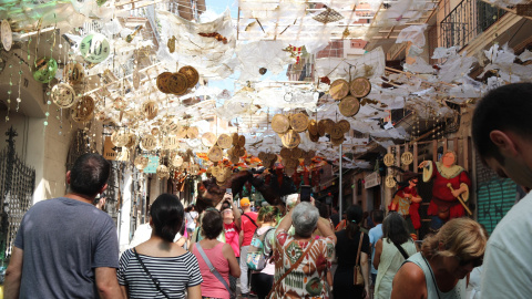 Gent fotografia el guarnit del carrer Verdi durant la Festa Major de Gràcia
