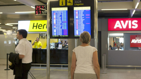 Una turista comprueba el estado de un vuelo en una pantalla del aeropuerto de Palma de Mallorca, en una jornada de huelga de controladores aéreos. EFE/MONTSERRAT T DIEZ