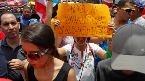 Una mujer sostiene una pancarta durante las protestas en San Juan / REUTERS Una mujer sostiene una pancarta durante las protestas en San Juan / REUTERS