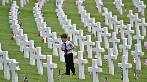Un niño camina junto a varias tumbas en el Cementerio Militar americano en Falciani, a las afueras de Florencia en Italia, durante la ceremonia en honor al día de los caídos, que conmemora a todos los hombres y mujeres estadounidenses que m