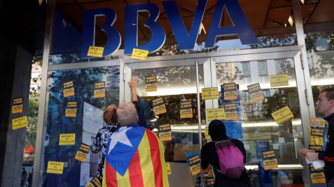 Manifestantes colocando pegatinas en una sucursal del BBVA. - EFE Manifestantes colocando pegatinas en una sucursal del BBVA. - EFE