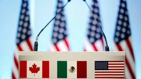 El atril adornado con las tres banderas que representan a los países del nuevo acuerdo USMCA - Reuters/Edgard Garrido El atril adornado con las tres banderas que representan a los países del nuevo acuerdo USMCA - Reuters/Edgard Garrido