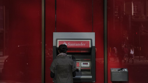 Una mujer utiliza un cajero automático en una oficina del Banco Santander en el centro de Londres. AFP/Carl Court Una mujer utiliza un cajero automático en una oficina del Banco Santander en el centro de Londres. AFP/Carl Court