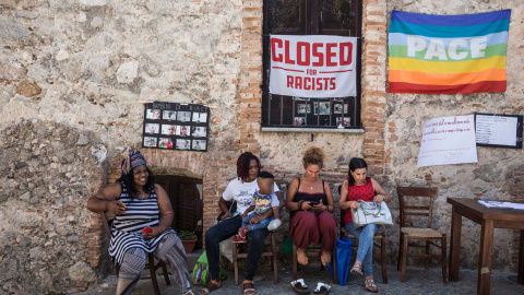 Migrantes y población local en la taberna Donna Rosa, epicentro de las protestas contra la decisión del Gobierno central y la Prefectura de bloquear los fondos. - G.S.