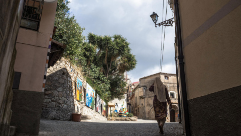 Una mujer pasa por una de las plazas de Riace. - G.S.