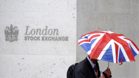 Una persona con un paraguas con los colores de la bandera británica delante de la entrada de la Bolsa de Londres. REUTERS/Toby Melville Una persona con un paraguas con los colores de la bandera británica delante de la entrada de la Bolsa de Londres. REUTERS/Toby Melville