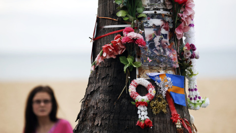 Una mujer observa el arbol decorado con fotos, flores y cintas, en recuerdo de los turistas suecos que murieron por el tsunami de 2004, en las playas de Khao Lak en Tailandia. REUTERS/Athit Perawongmetha