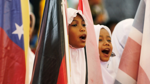 Unas niñas de la provincia indonesia de Aceh cantan y sostienen banderas en la ceremonia para recordar a las víctimas del tsunami de 2004. REUTERS/Beawiharta