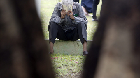 Un hombre reza en una fosa común de víctimas del tsunami en Banda Aceh (Indonesia). EFE/Adi Weda