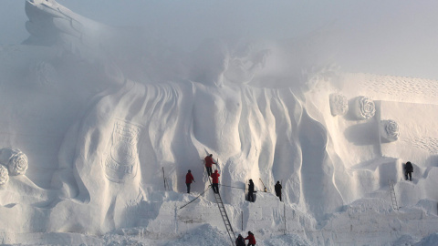 Varios artistas pulen una escultura de nieve en un parque en Changchun, provincia de Jilin. /REUTERS/STR