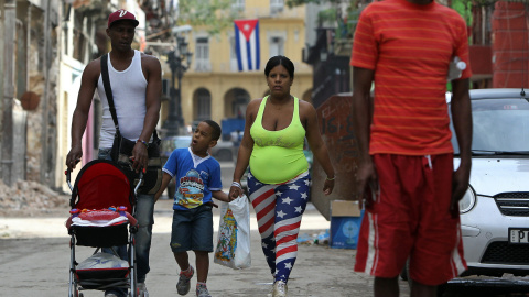 Una mujer vestida con la bandera de Estados Unidos camina junto a su familia en una calle de La Habana (Cuba). EFE/Alejandro Ernesto