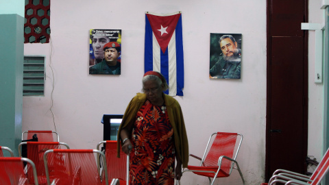 Una anciana camina en un Centro Para Atención a la Tercera Edad decorado con fotos de Fidel Castro y Hugo Chávez, en La Habana (Cuba). EFE/Alejandro Ernesto
