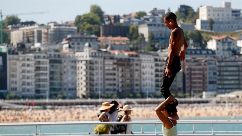 Unos jóvenes practican acrobacias junto a la playa de la Concha de San Sebastián / EFE - JUAN HERRERO Unos jóvenes practican acrobacias junto a la playa de la Concha de San Sebastián / EFE - JUAN HERRERO