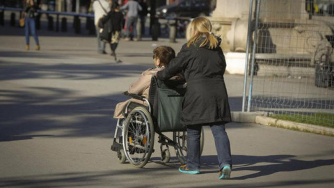 Una mujer mayor pasea con su cuidadora. EFE Una mujer mayor pasea con su cuidadora. EFE