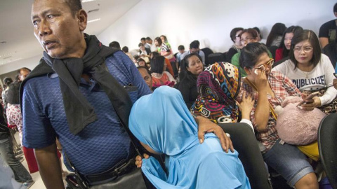 Familiares de los pasajeros desaparecidos esperan noticias sobre el paradero del avión en el aeropuerto de Juanda, en Indonesia. EFE