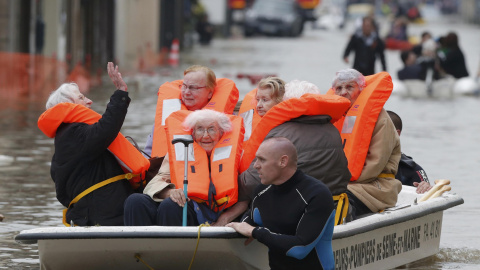 Bomberos franceses evacúan en pequeñas embarcaciones a los residentes de un área inundada por la crecida del Sena.-REUTERS / Christian Hartmann