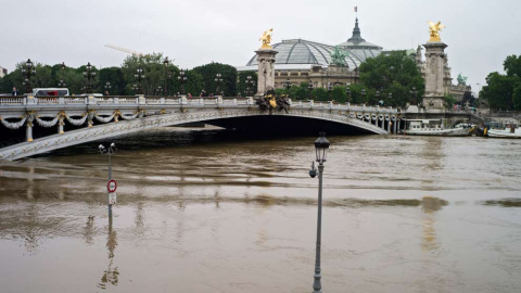 Las lámparas del puente de Alexandre III, uno de los más emblemáticos de la ciudad, han quedado también parcialmente sumergidas. / EFE