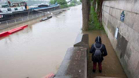 Un peatón se acerca a observar de cerca la crecida del río Sena. / EFE