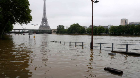 Una imagen nada habitual de la Torre Eiffel desde la orilla del Sena: se puede apreciar qué nivel ha alcanzado el agua. / REUTERS
