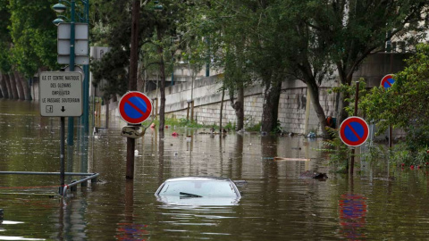 Hasta los coches y las señales de tráfico han sucumbido al furor de las aguas. / REUTERS
