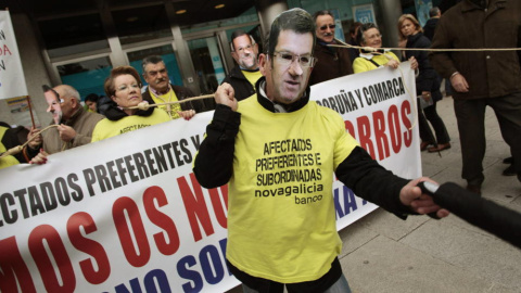 Dos afectados por las preferentes, con máscaras de Feijóo y Rajoy, durante una protesta. / EFE Dos afectados por las preferentes, con máscaras de Feijóo y Rajoy, durante una protesta. / EFE