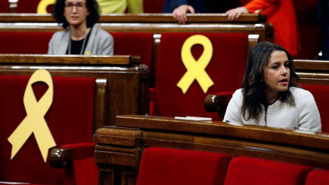 La líder de Ciutadans, Inés Arrimadas (d), y la secretaria general de ERC, Marta Rovira (i), junto a varios escaños vacios adornados con lazos amarillos. | EFE