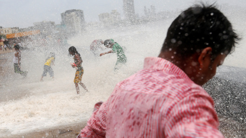 Un grupo de personas de mojan con el impacto de una ola en Mumbai, India. REUTERS/Danish Siddiqui