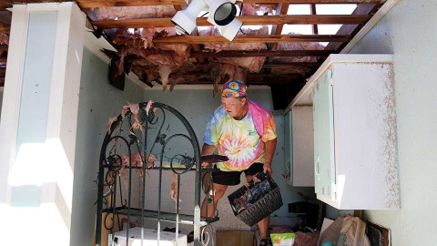 Mary Norris se para en el mostrador de la cocina y saca las pertenencias de la casa destruida de su amiga tras del huracán Michael en Mexico Beach, Florida, EE. UU., 11 de octubre de 2018. REUTERS / Carlo Allegri