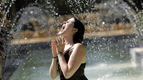 Una chica se refresca durante la ola de calor de 2015./EFE Una chica se refresca durante la ola de calor de 2015./EFE