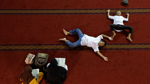 Mujeres leen el Corán mientras los niños descansan dentro de la mezquita Istiqlal durante el Ramadán en Jakarta, Indonesia. REUTERS/Beawiharta