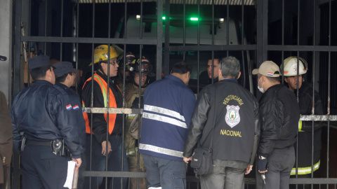 Bomberos y policías evaluando los daños del incendio ocurrido en la cárcel de Tacumbú en el que murió un jefe de seguridad mientras ayudaba en la evacuación de los internos , en Asunción , Paraguay.- REUTERS / Jorge Adorno medios de comunic