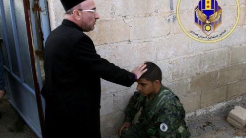 Sacerdote bendice a un miliciano del Consejo Militar Siriaco de Siria. Sacerdote bendice a un miliciano del Consejo Militar Siriaco de Siria.