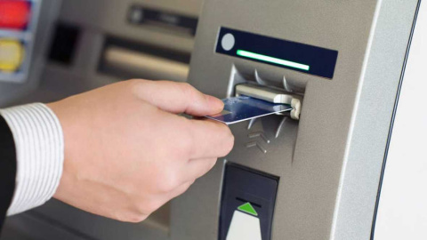 Un hombre saca dinero de un cajero automático. Un hombre saca dinero de un cajero automático.