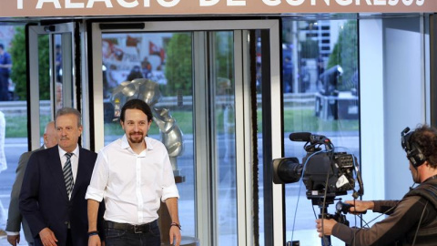 El candidato por Unidos Podemos a la presidencia del Gobierno, Pablo Iglesias (d), acompañado por el presidente de la Academia de la Televisión, Manuel Campo Vidal (i), a su llegada al Palacio Municipal de Congresos de Madrid, donde se cele