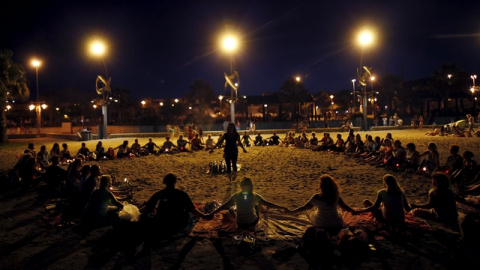 La gente forma parte de un ritual para celebrar San Juan y llamar a la buena suerte en la Playa de la Misericordia de Málaga./ REUTERS/Jon Nazca