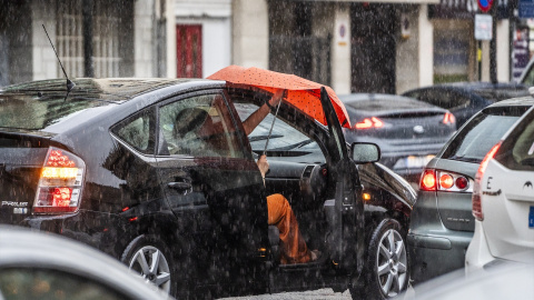 Una se sube a un coche bajo la lluvia, a 3 de julio de 2023, en Valencia, País Valencià. Una se sube a un coche bajo la lluvia, a 3 de julio de 2023, en Valencia, País Valencià.