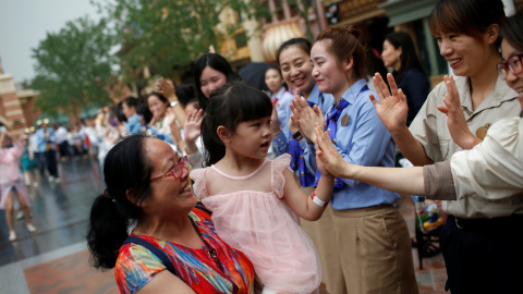 Una niña recibe la bienvenida del personal del Resort de Disney en Shangai al momento de su apertura
