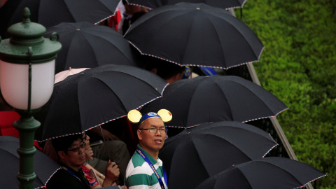 Un hombre con las orejas de Mickey Mouse mira expectante la gala de inauguración