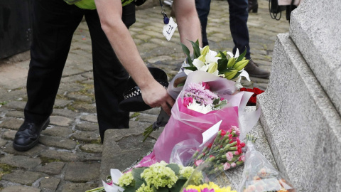 Un policía deja flores en el Birstall, el lugar del crimen de la diputada laborista