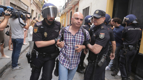 David Navarro, concejal de Por Cádiz sí se puede, es llevado por dos policías nacionales durante el desahucio ejecutado a una familia de la casa donde vivían en Cádiz en régimen de alquiler. EFE/Román Ríos David Navarro, concejal de Por Cádiz sí se puede, es llevado por dos policías nacionales durante el desahucio ejecutado a una familia de la casa donde vivían en Cádiz en régimen de alquiler. EFE/Román Ríos