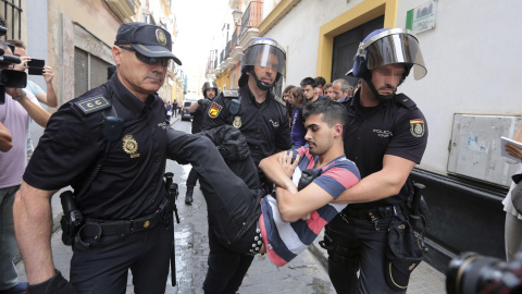 Agentes de la Policía Nacional llevan a una de las personas que intentaban evitar un desahucio a una familia que vivía en su casa de Cádiz en régimen de alquiler pero que finalmente ha sido desalojada por orden judicial. EFE/ Román Ríos Agentes de la Policía Nacional llevan a una de las personas que intentaban evitar un desahucio a una familia que vivía en su casa de Cádiz en régimen de alquiler pero que finalmente ha sido desalojada por orden judicial. EFE/ Román Ríos